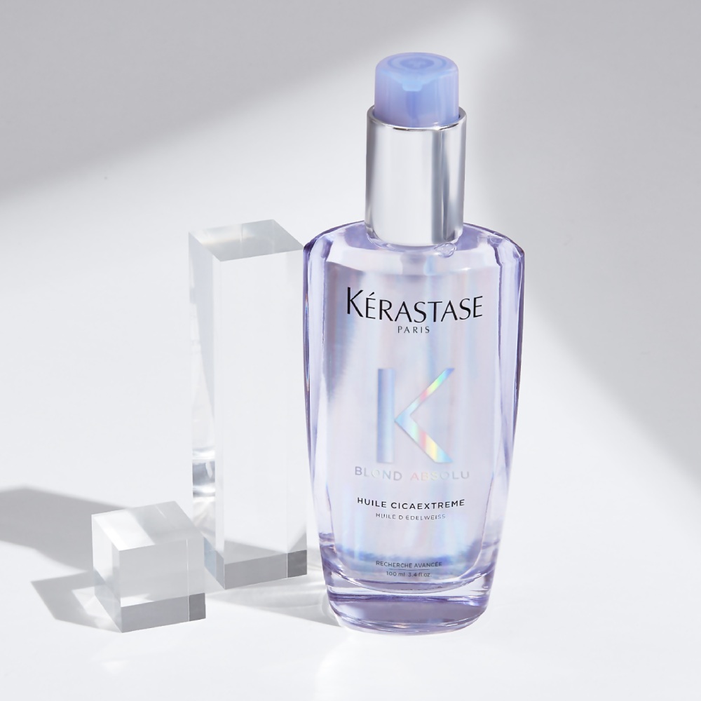  Huile Cicaextreme hair oil is displayed on a pure grey background with transparent cubes. The oil provides strength and shine to bleached and blonde hair.